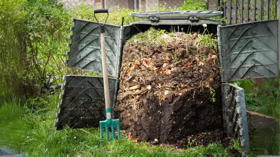 A bin filled with layers of green and brown materials for compost